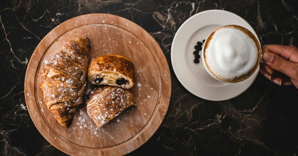 Flat White vs Cappuccino - Croissant and a coffee on a table